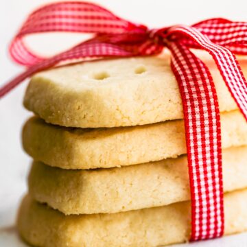 A stack of four rectangular gluten free shortbread cookies wrapped in a red ribbon.