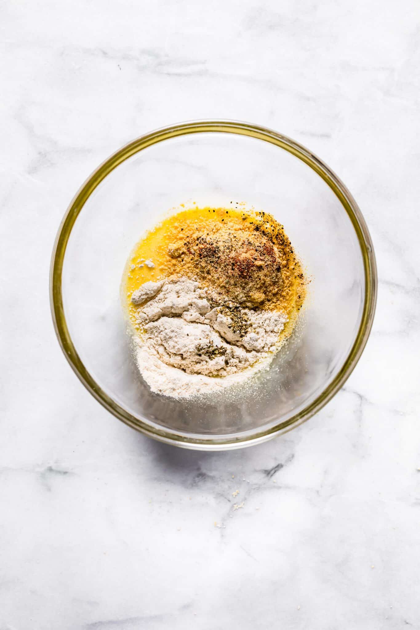 bowl of ingredients to make tuna patties. Egg, flour, spices.