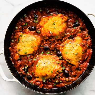 Overhead photo of Skillet Chicken Puttanesca recipe in a cast iron skillet.