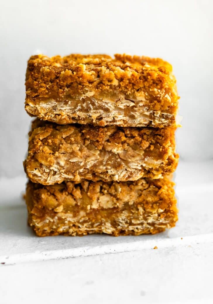 Stack of gluten-free apple crisp bars with golden oat crumble topping and spiced apple filling.