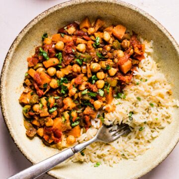 Sweet potato picadillo and rice in a ceramic bowl with a fork.