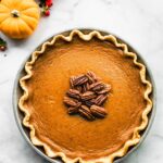 Whole gluten-free pumpkin pie with pecans on top