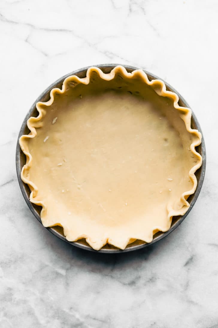 Gluten Free Pumpkin Pie Crust in metal pie plate with crimped edges.