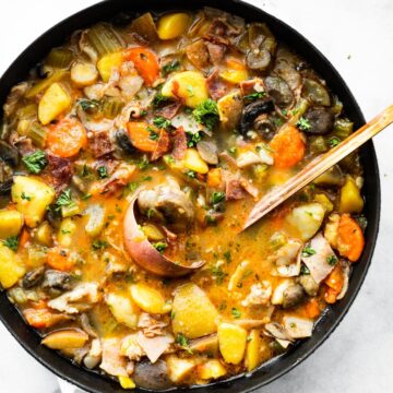 overhead shot of vegetable soup in pot with ladle in the middle