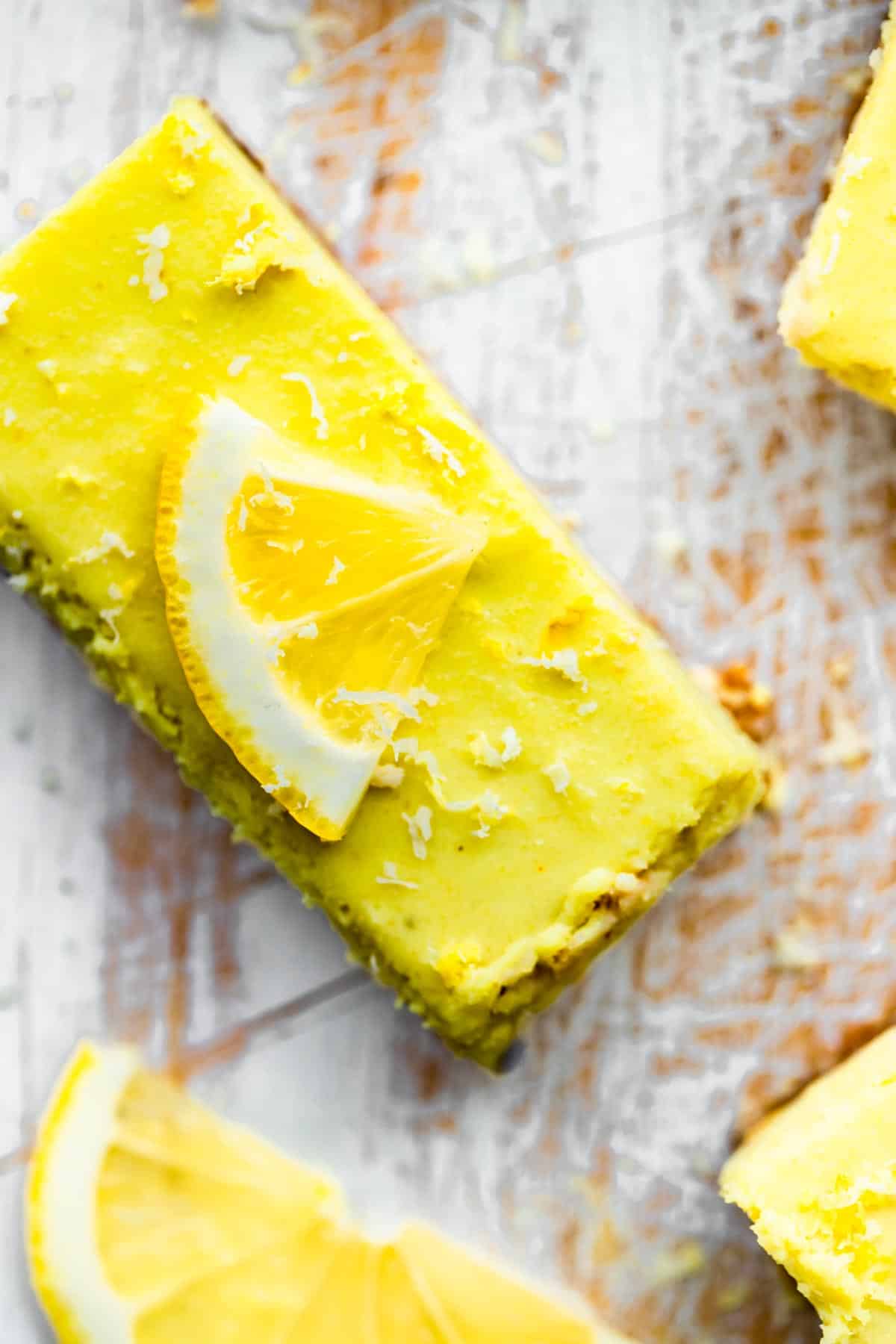 No Bake Lemon Cheesecake Bars topped with a lemon.