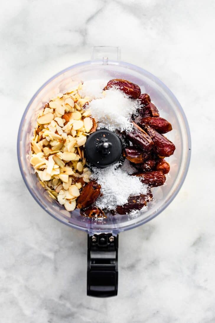 Almonds, shredded coconuts, and dates in a food processor.