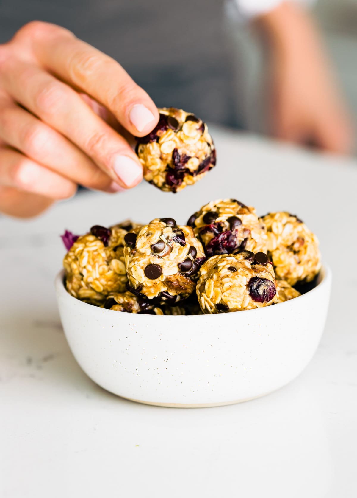 Woman holding an oatmeal energy bites in a bowl
