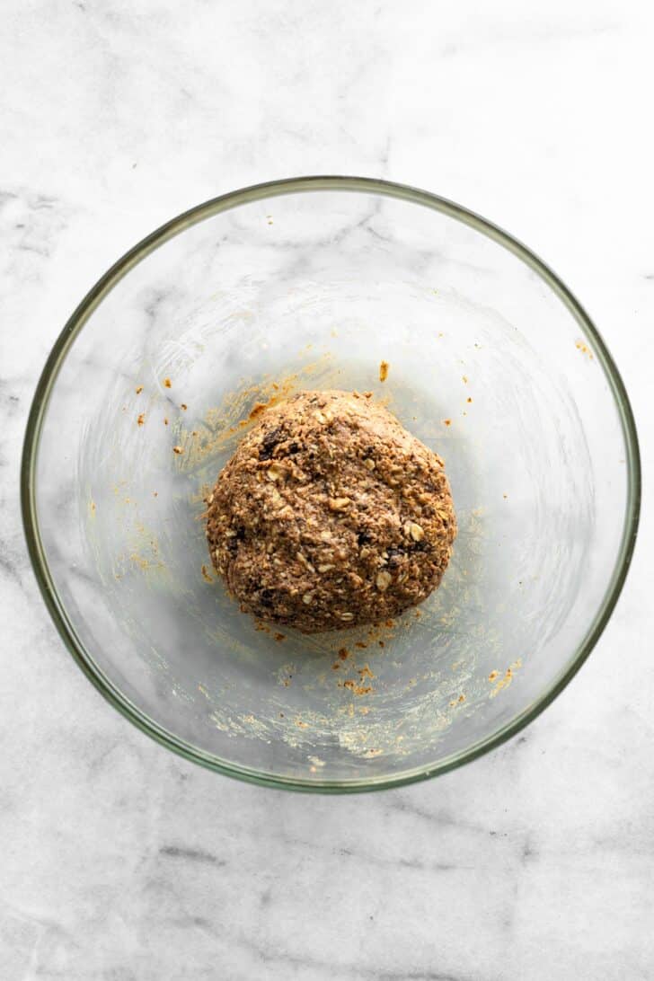 Combined pecan pie ball dough formed into a single ball in a glass mixing bowl.