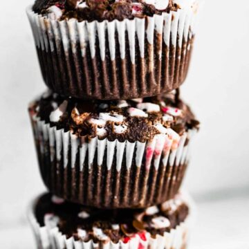 A stack of three gluten free Peppermint Chocolate Muffins on a white countertop.