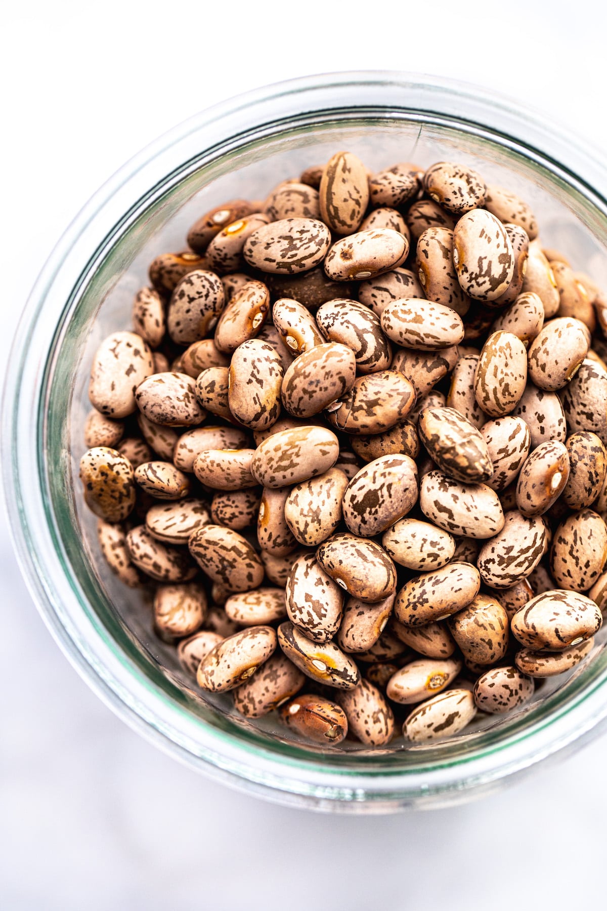 Overhead close up shot of Pinto Beans in a glass jar.