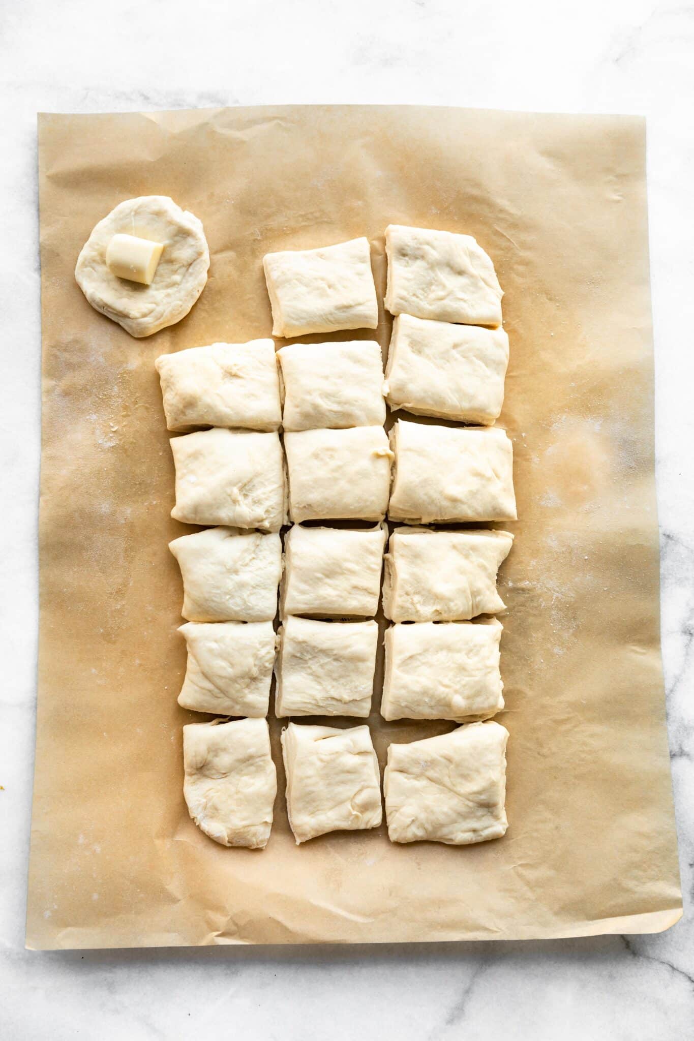 Pizza dough rolled flat into a rectangle cut into squares.