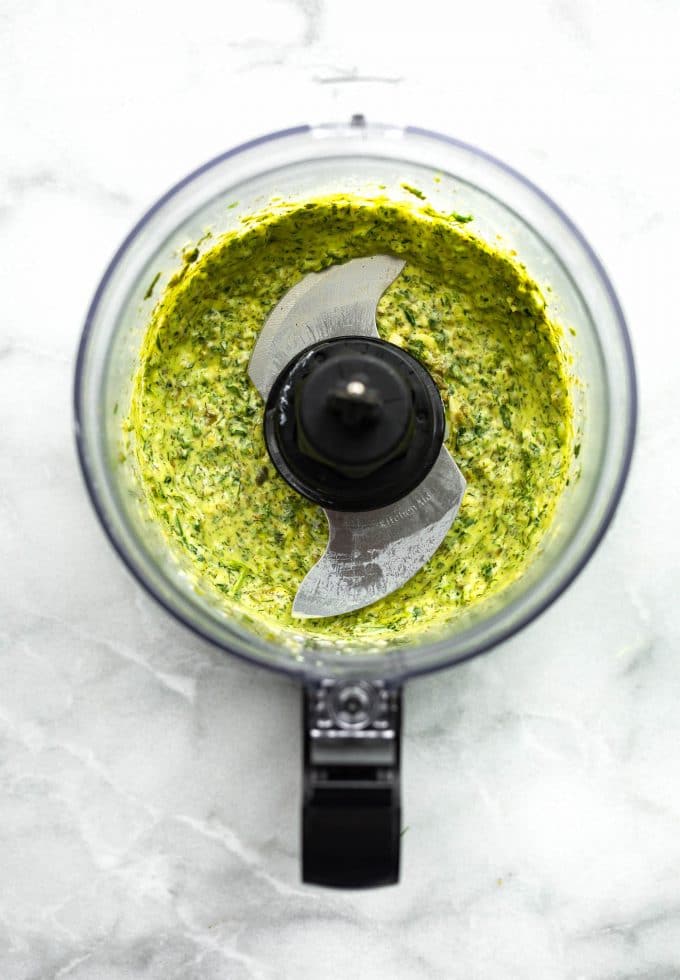 Bright green blended herb sauce in a food processor.