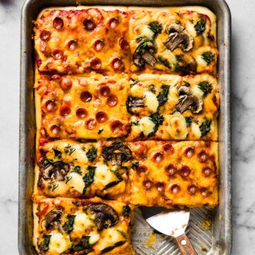 One slice removed from a sheet pan pizza.