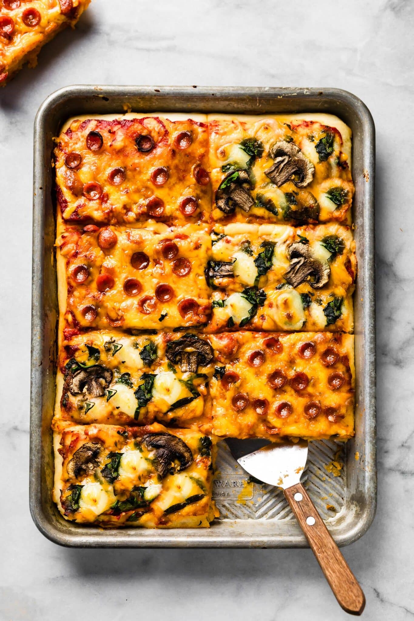 One slice removed from a sheet pan pizza.