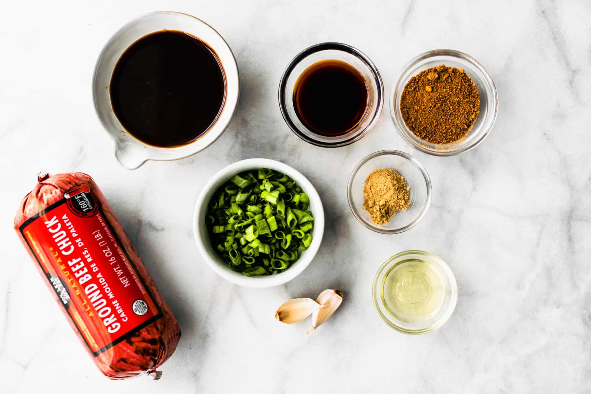 Ingredients for Saucy Asian Meatballs on a white marble countertop.