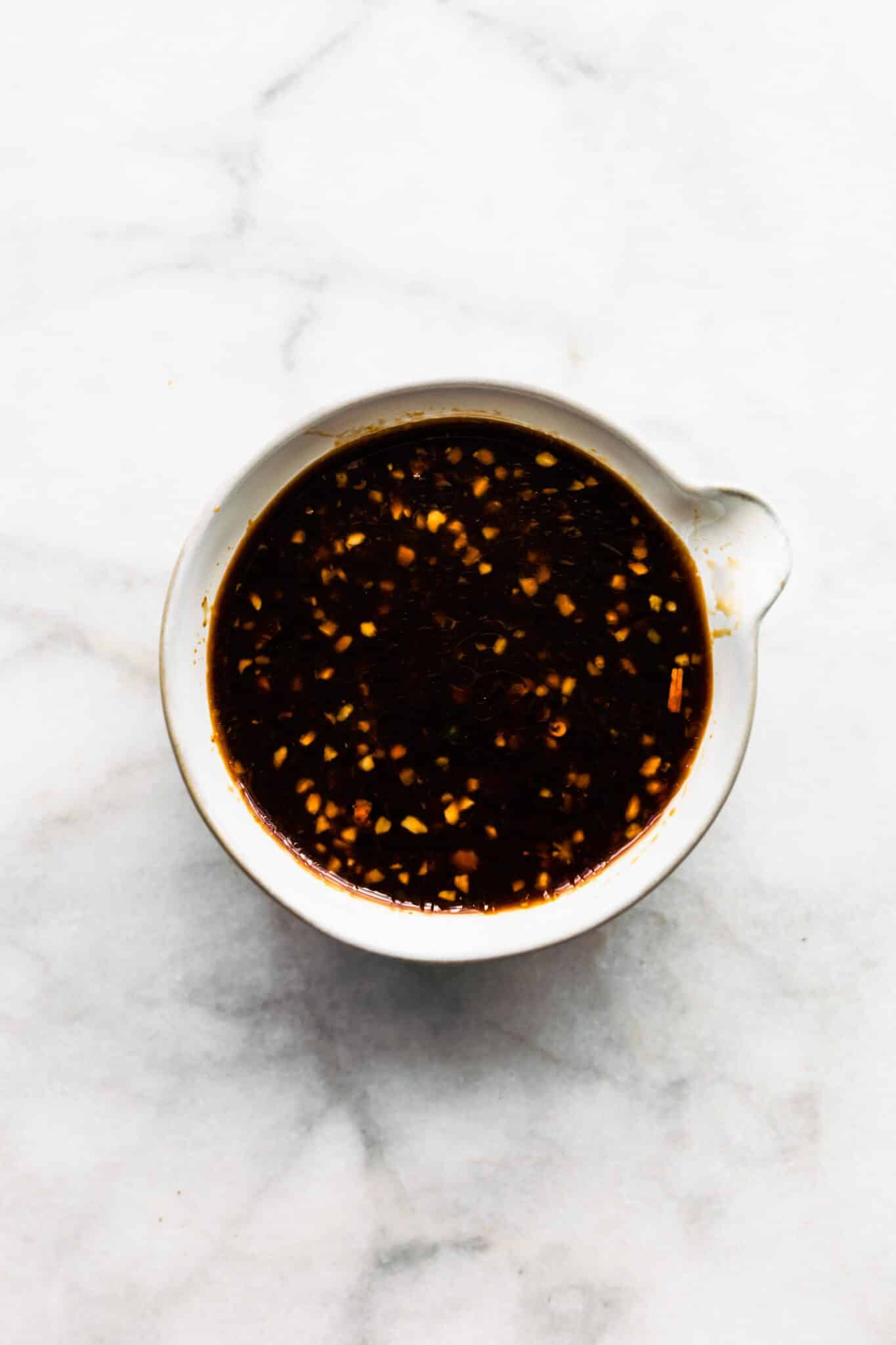 Overhead photo of an Asian sauce in a white bowl.