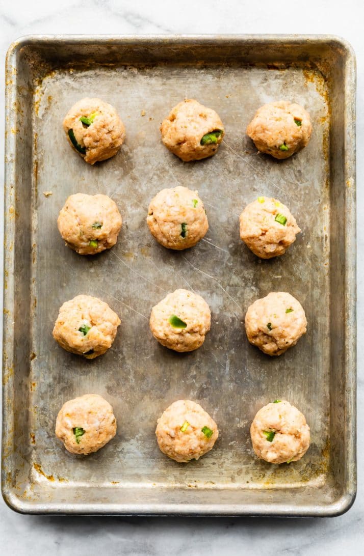 raw gluten free meatballs on a baking sheet