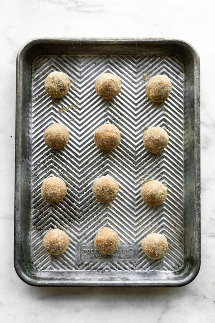 no bake coated protein balls stacked on a sheet pan