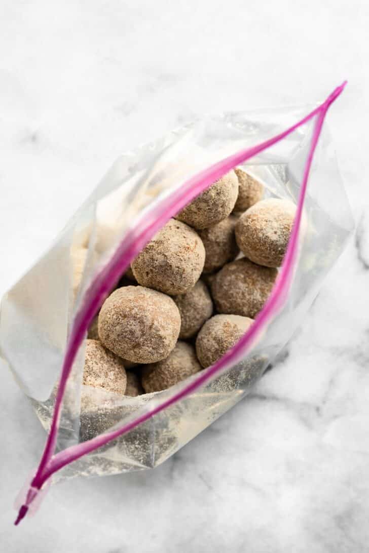 no bake coated protein balls stacked in a ziplock bag