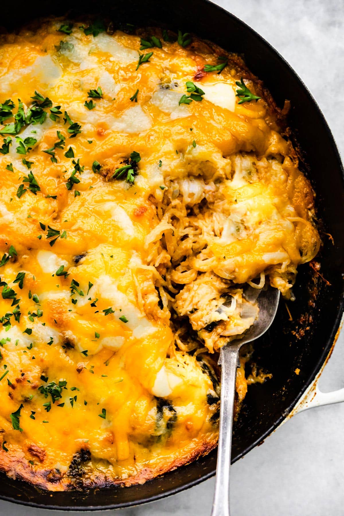 Overhead photo of gluten free spaghetti squash casserole with a spoon in it.