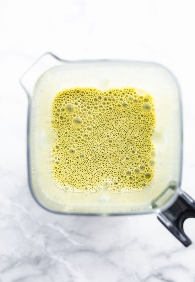 Blended kale and berry smoothie inside a blender