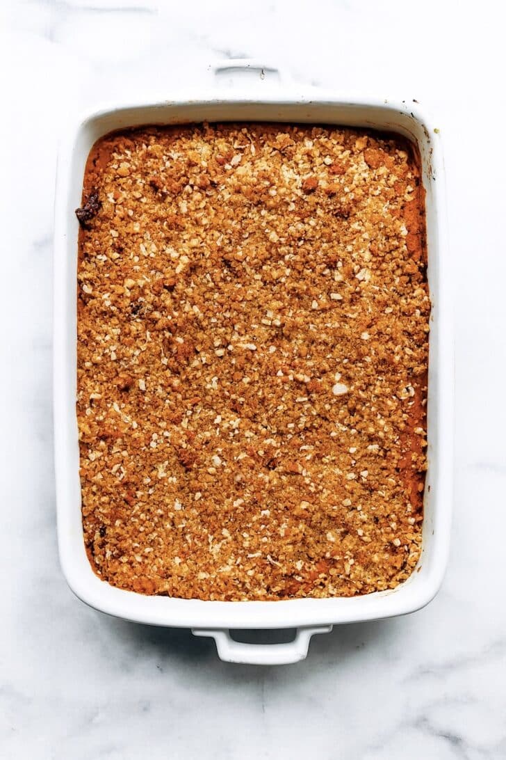 sweet potato casserole in a white casserole dish with a golden nutty topping