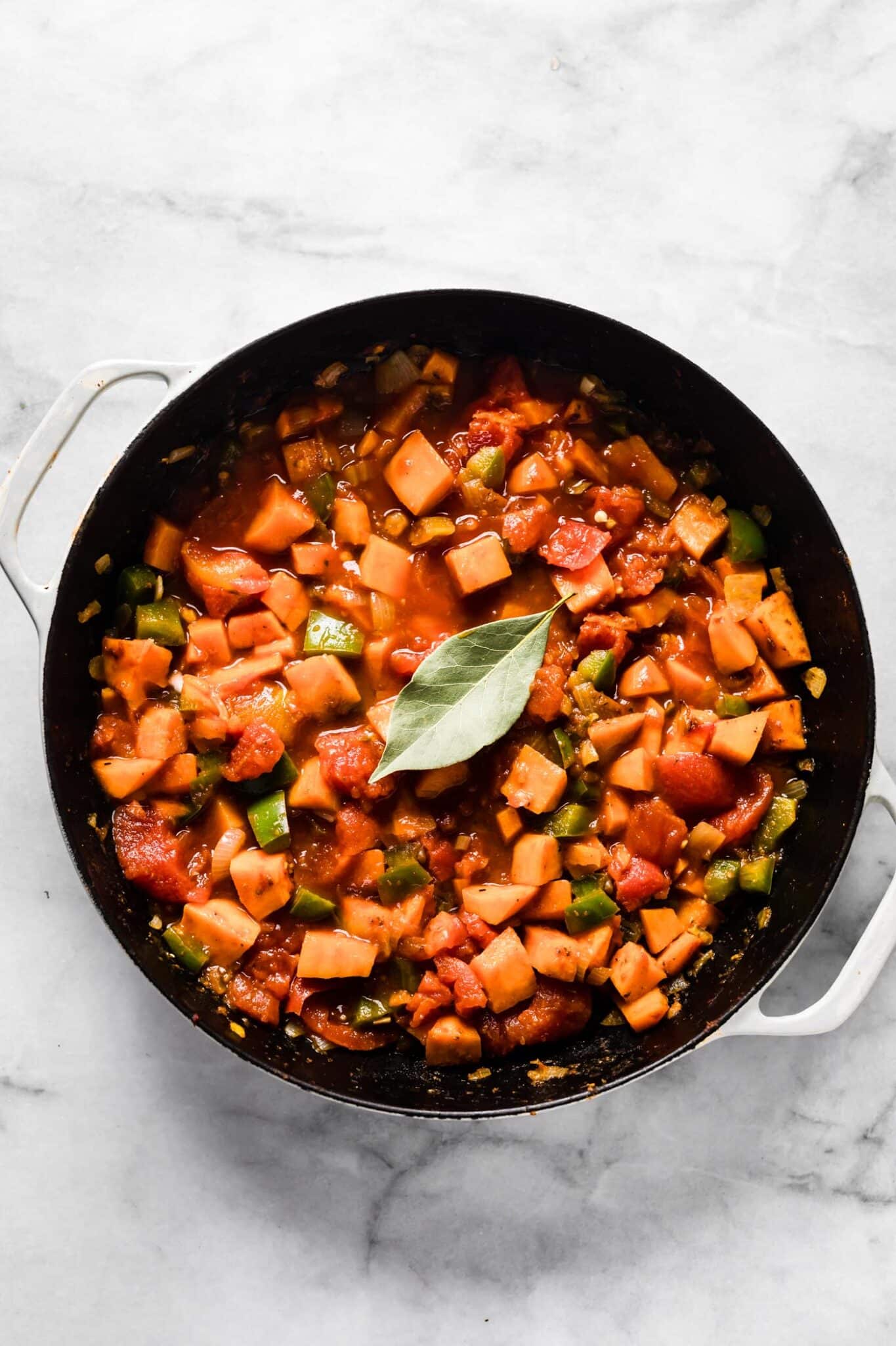 Bay leaf on top of sweet potato picadillo in the cooking pot.
