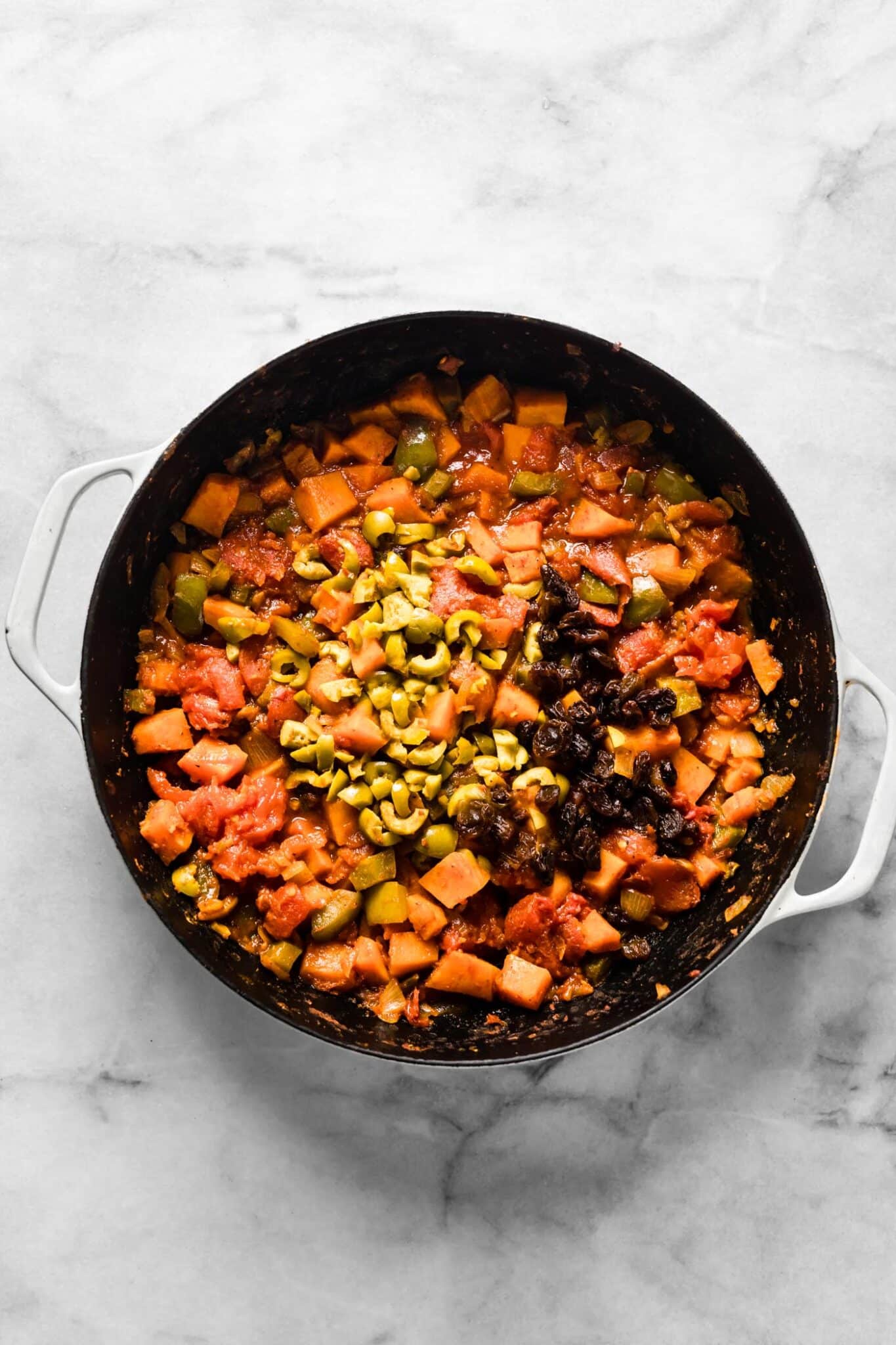 Chopped olives and raisins ready to be stirred into sweet potato picadillo.