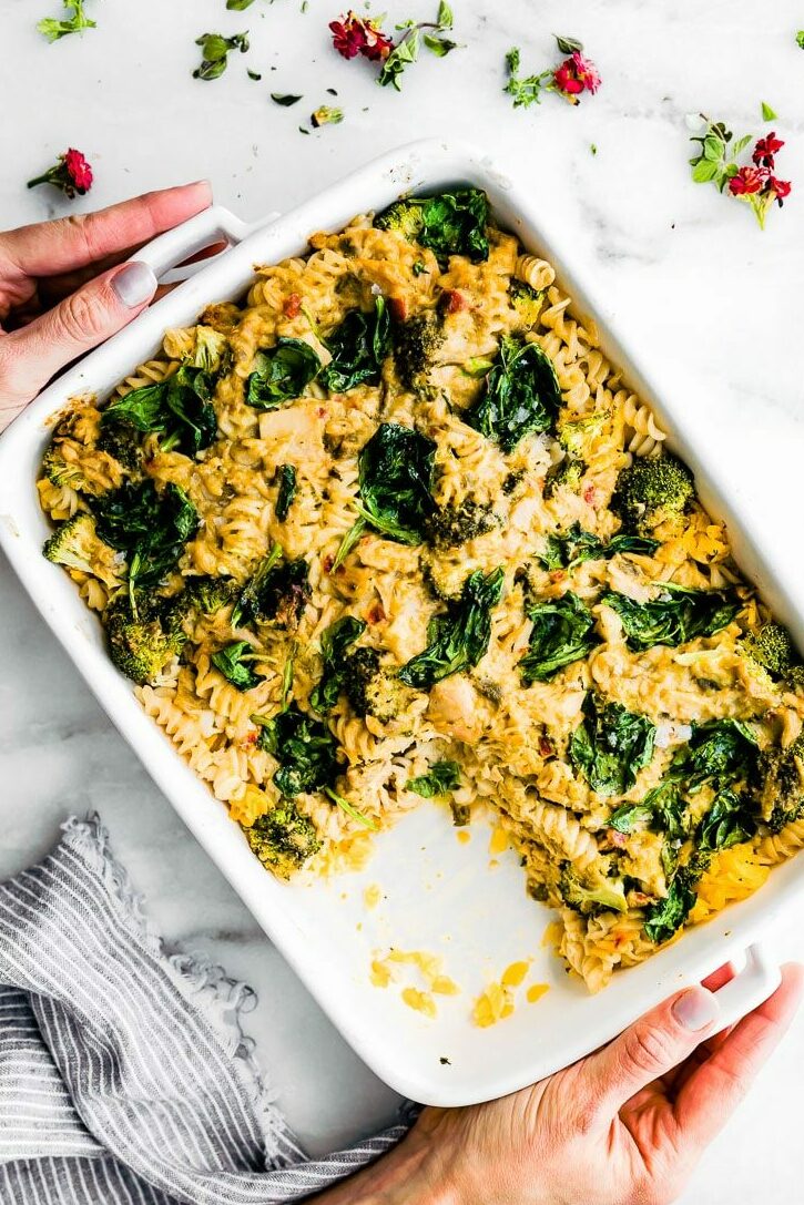 Overhead shot of hands holding a pan full Tuna Noodle Casserole