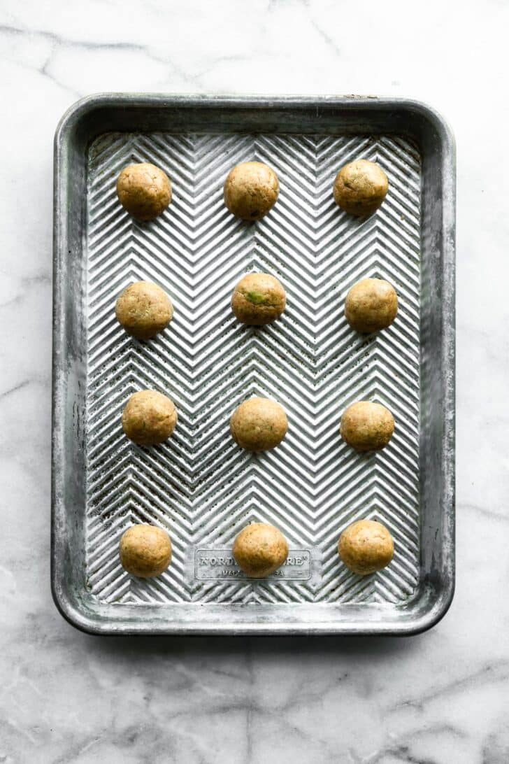 protein balls lined up on a baking sheet