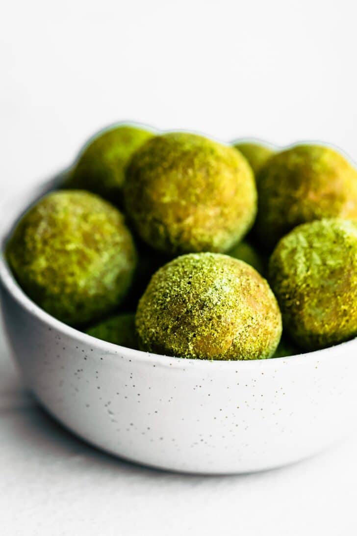 white bowl of green matcha protein bites