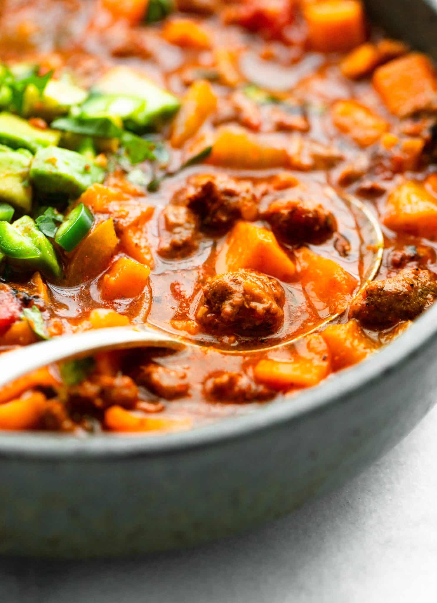 Up close photo of a spoon in a bowl of chipotle sweet potato chili.