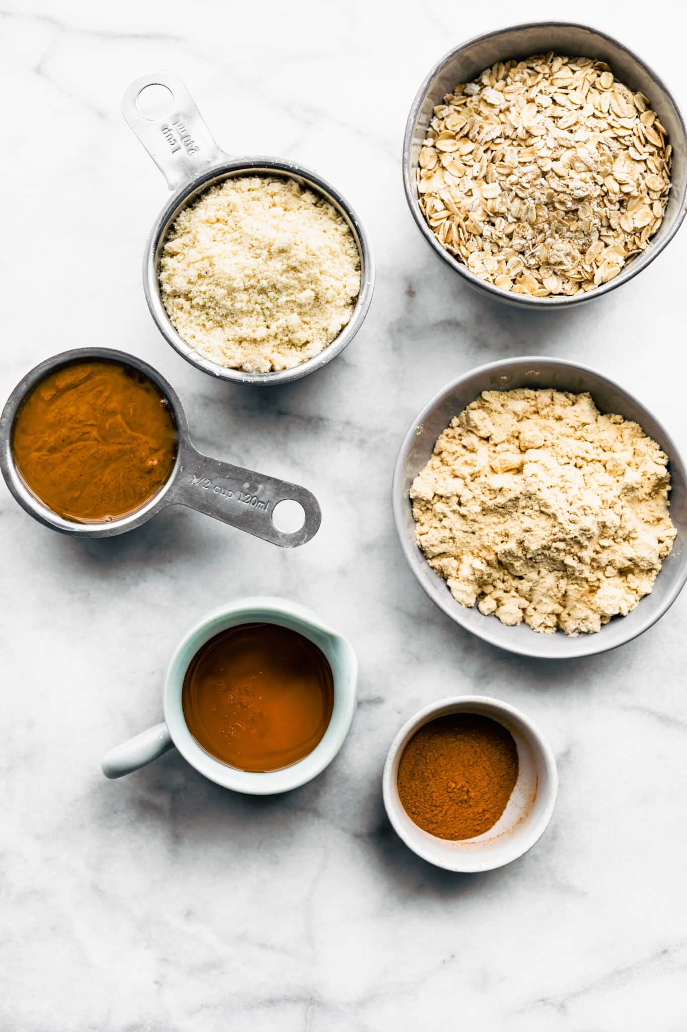 Ingredients in small bowls and measuring cups for cinnamon breakfast balls.