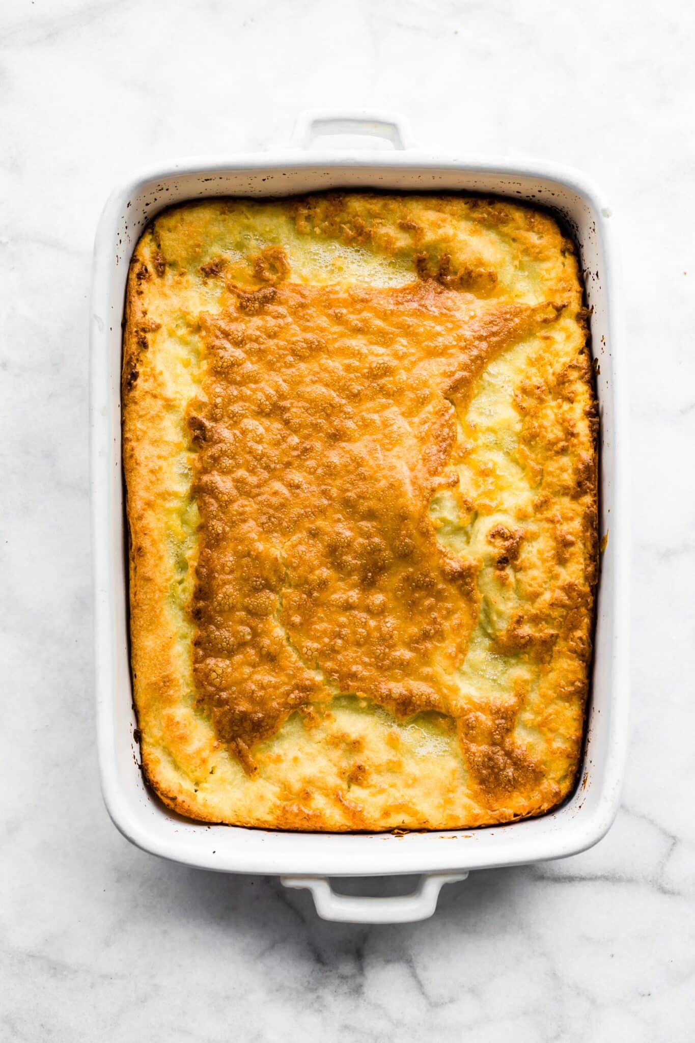 Overhead photo of a fluffy golden brown gluten free Swedish Pancake in a baking dish.