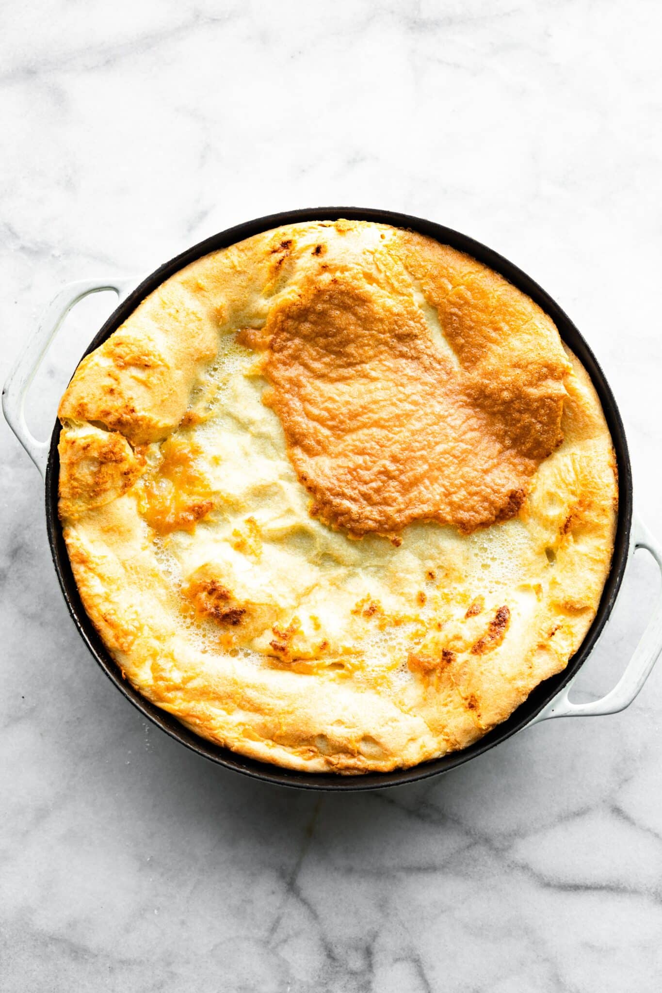 A puffy Gluten Free Swedish Baked Pancake in a cast iron pan.
