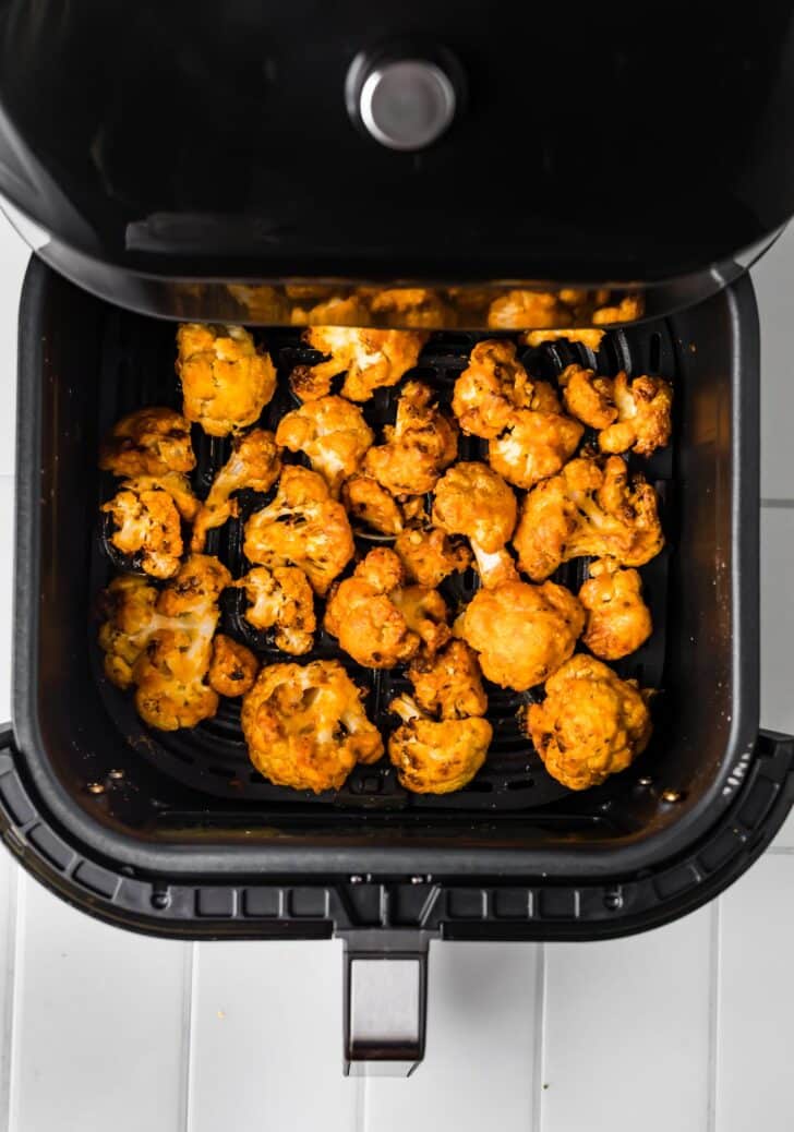 Overhead photo of air fried buffalo cauliflower in an air fryer basket.