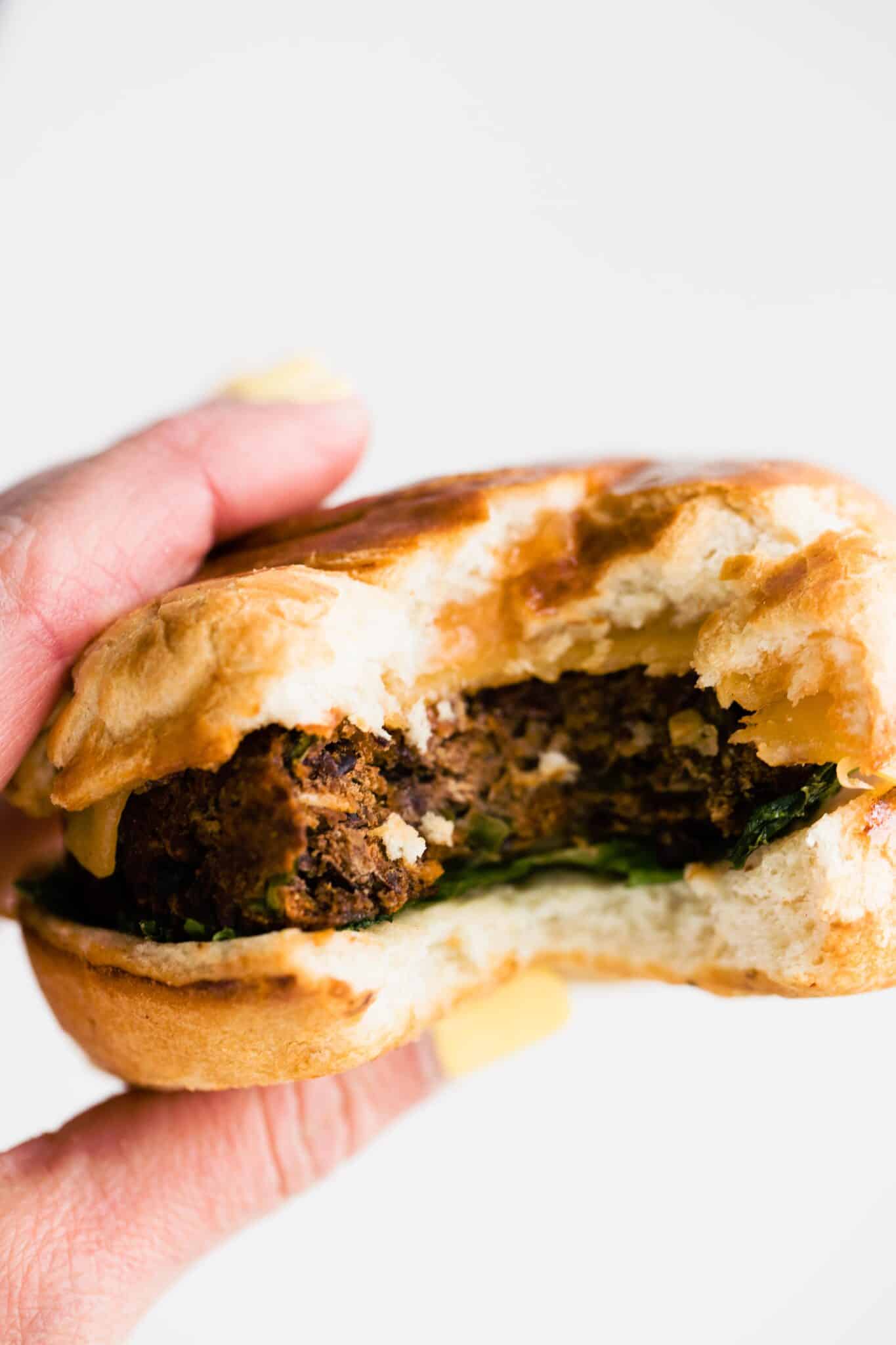 Up close photo of a black bean burger in a woman's hands.