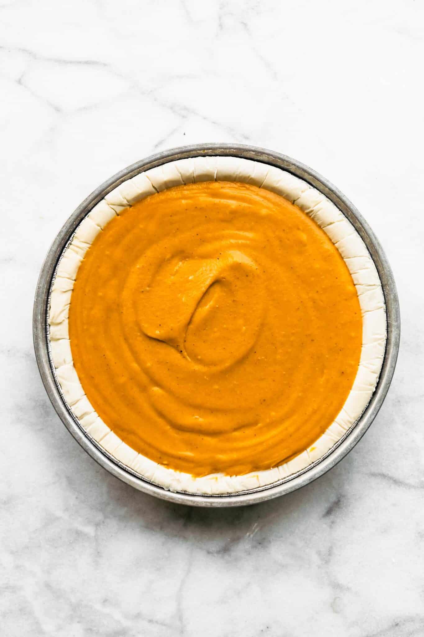 Overhead photo of pumpkin pie filling in a pie shell.