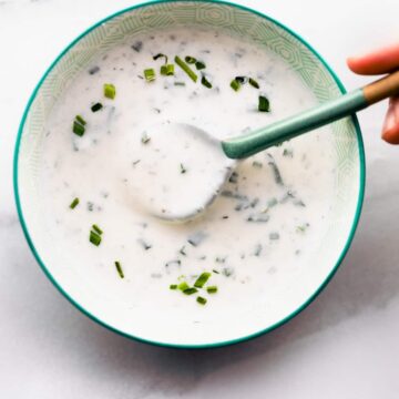 overhead: spoonful of vegan salad dressing above small green bowl filled with more dressing